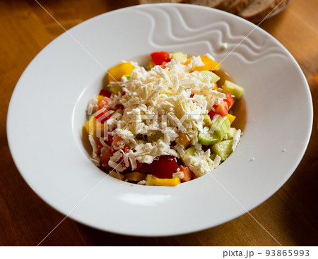 Shopska salad - dish of Balkan cuisine. Cucumbers, tomatoes, bell peppers and brynza Shopska salad - dish of Balkan cuisine. Cucumbers, tomatoes, bell peppers and brynza 93865993