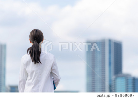 都市を眺める白衣の女性 93869097
