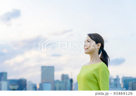 都市の前で遠くを眺める女性 93869126