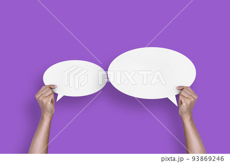 hand holding round white paper balloons speech bubbles isolated on purple background 93869246