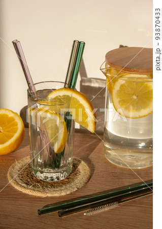 Glass of water with fresh lemon juice with Reusable glass Straws Detox cold tonic water with sunny lemon slices Low-waste lifestyle Eco-Friendly Drinking Straw Glass of water with fresh lemon juice with Reusable glass Straws Detox cold tonic water with sunny lemon slices Low-waste lifestyle Eco-Friendly Drinking Straw 93870433