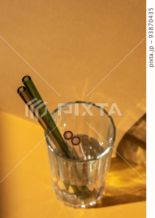 Reusable glass Straws in Glass with water on beige neutral background Eco-Friendly Drinking Straw Set with cleaning brush. Zero waste, plastic free concept Reusable glass Straws in Glass with water on beige neutral background Eco-Friendly Drinking Straw Set with cleaning brush. Zero waste, plastic free concept 93870435