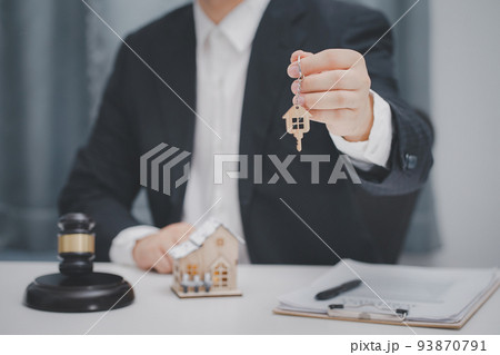 Male lawyer or judge delivering keys to customer. Real estate law and house auction concept. Male lawyer or judge delivering keys to customer. Real estate law and house auction concept. 93870791