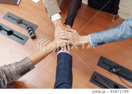 Top view of group coworkers stacked hands together as concept of corporate unity Top view of group coworkers stacked hands together as concept of corporate unity 93871799