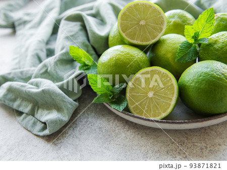 Green Limes with fresh mint leaves on plate Green Limes with fresh mint leaves on plate 93871821