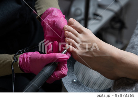 The master makes hardware pedicures to the client. Cuticle treatment. The master makes hardware pedicures to the client. Cuticle treatment. 93873269