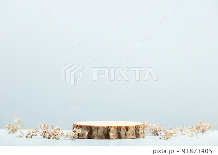 Wood slice podium and dry flowers on blue background for cosmetic product mockup 93873405