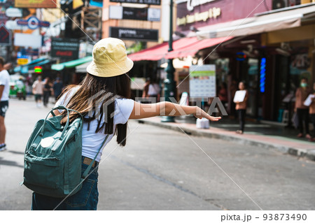 Young asian woman flag down a taxi. Young asian woman flag down a taxi. 93873490