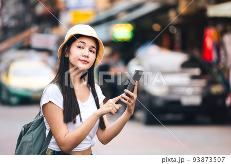 Solo woman sightseeing with modern technology use smart phone for taxi. Solo woman sightseeing with modern technology use smart phone for taxi. 93873507