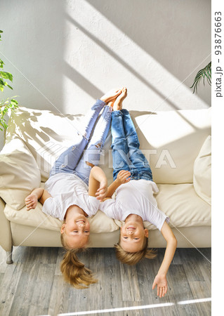 Pretty little girl and boy are lying on sofa in living room 93876663
