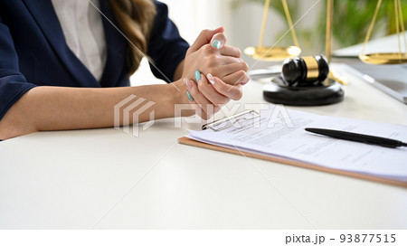 A professional and serious female lawyer sitting at her office desk. cropped image A professional and serious female lawyer sitting at her office desk. cropped image 93877515