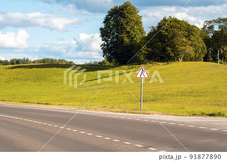 Country road and pedestrians in road sign 93877890