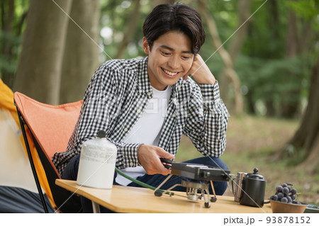 ソロキャンプを楽しむ男性・ホットサンドづくり 93878152
