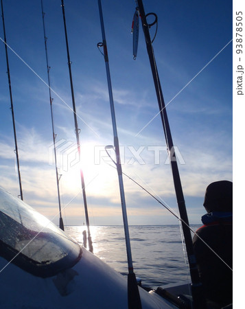 秋晴れの早朝、ロッドスタンドに竿を立てて沖へと向かうプレジャーボートの風景写真。 93878505