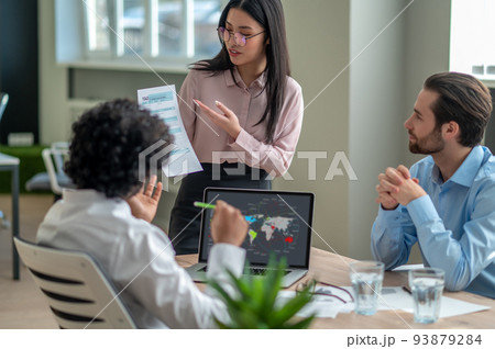 Long-haired brunette talking with business partners in the office Long-haired brunette talking with business partners in the office 93879284