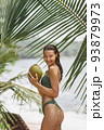 Asian Woman With Coconut Under Palm Tree on the Beach on Summer Vacation 93879973