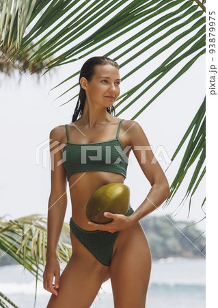 Asian Woman With Coconut Under Palm Tree on the Beach on Summer Vacation 93879975