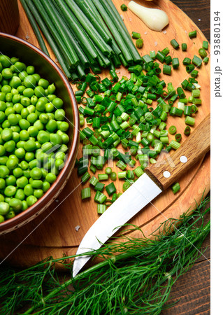 green onions, dill and peas on a wooden background, still life, sliced vegetables on a kitchen board, concept of fresh and healthy food green onions, dill and peas on a wooden background, still life, sliced vegetables on a kitchen board, concept of fresh and healthy food 93880194