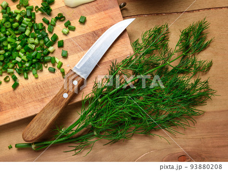 vegetables on a wooden kitchen board, sliced green onions, dill and peas on a wood background, concept of fresh and healthy food, still life 93880208