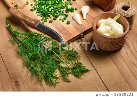 vegetables on a wooden kitchen board, sliced green onions, dill and peas on a wood background, concept of fresh and healthy food, still life 93880221