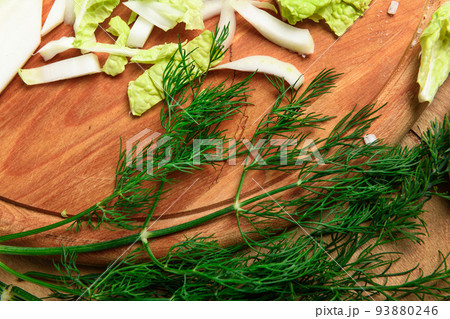 vegetables on a wooden kitchen board, green onions, dill and peas, sliced cabbage on a wood background, concept of fresh and healthy food, still life 93880246