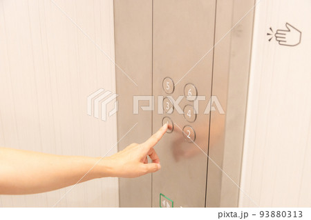 エレベーターのボタンを押す女性の手 93880313
