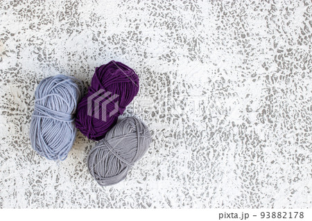 Gray and purple yarn on gray texture background with copy space 93882178
