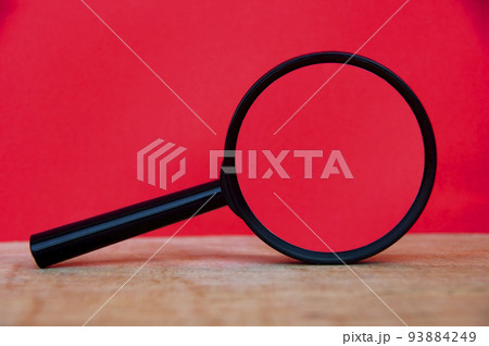 Magnifying glass on wooden desk with space customizable for text or ideas. Copy space 93884249