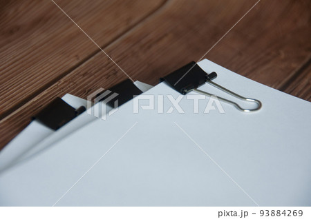 Paper stack of clipped pile of documents on wooden desk. Copy space and business offices concept Paper stack of clipped pile of documents on wooden desk. Copy space and business offices concept 93884269