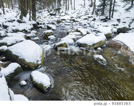 Snow covered stones in Mumlava river stream in Krkonose National Park, Czech Republic, winter seasonal background 93885363