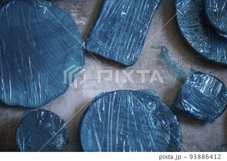 Small plates wrapped in blue cling film placed on brown wooden floor background. Top view. Copy Space. Flat Lay 93886412