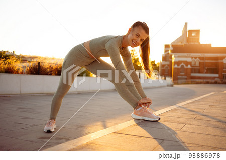 Female runner stretching before running Female runner stretching before running 93886978