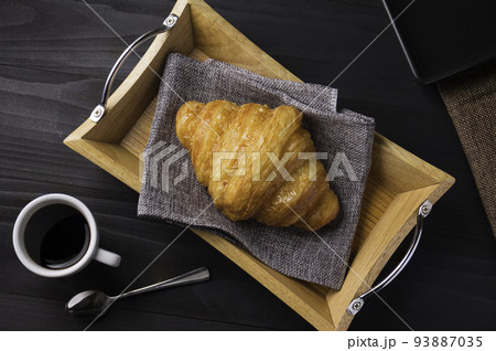Freshly baked croissants , served with coffee for breakfast 93887035