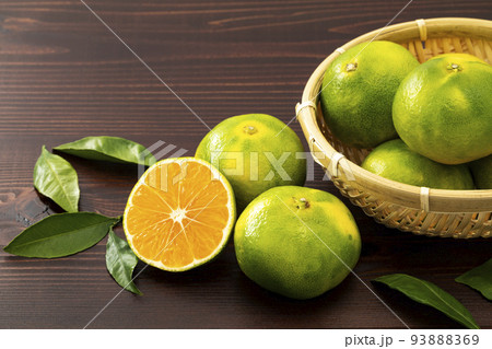 輪切りと竹ざるに入れ葉を添えた極早生みかん 93888369