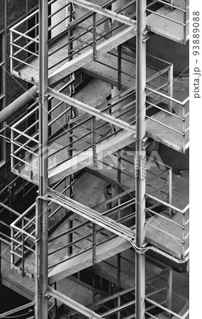 Staircase at an industrial plant, stairs made of iron and steel grates in abstract geometric arrangement, black and white Staircase at an industrial plant, stairs made of iron and steel grates in abstract geometric arrangement, black and white 93889088