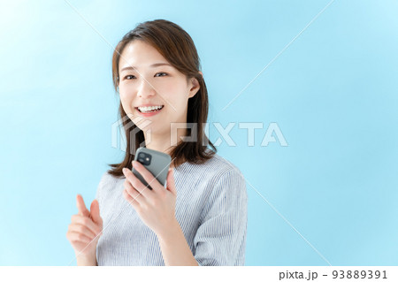 女性　スマートフォン　ブルーバック 93889391