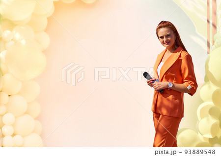 Presenter, wedding karaoke host.Young woman with a microphone with yellow banner Presenter, wedding karaoke host.Young woman with a microphone with yellow banner 93889548