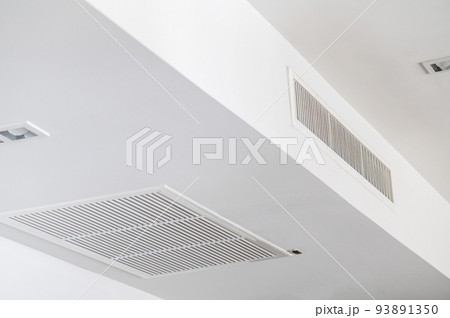 Ceiling mounted cassette type air conditioner and modern lamp light on white ceiling. duct air conditioner for home or office 93891350