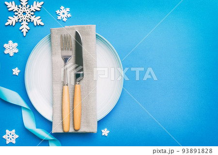 Christmas table place setting with christmas decor and plates, kine, fork and spoon. Christmas holiday background. Top view with copy space Christmas table place setting with christmas decor and plates, kine, fork and spoon. Christmas holiday background. Top view with copy space 93891828