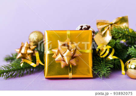 New Year Christmas mood, gift box, branches of a christmas tree, New Year decorations on a colored background New Year Christmas mood, gift box, branches of a christmas tree, New Year decorations on a colored background 93892075