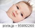 Portrait of a six-month-old baby girl, who lies on her back in her crib. 93892260
