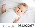 Charming baby on a white bed in the bedroom. 93892267