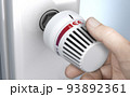 Man setting thermostat temperature to the higher position. 93892361