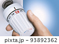 Man reducing energy consumption by setting thermostat temperature to 19 degrees. 93892362