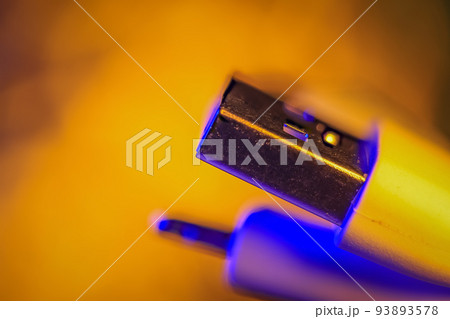 Close up view of USB connector, backlit with blue and yellow light 93893578