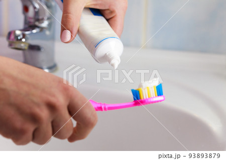 Hand applied toothpaste on toothbrush Hand applied toothpaste on toothbrush 93893879