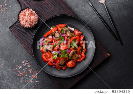 A salad of baked mushrooms, tomatoes, onions, parsley, spices and herbs 93894859