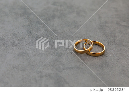 Will you marry me. Two golden wedding rings on concrete stone grey background. Engagement marriage proposal wedding concept. Banner on wedding day with copy space. Wedding day details Will you marry me. Two golden wedding rings on concrete stone grey background. Engagement marriage proposal wedding concept. Banner on wedding day with copy space. Wedding day details 93895284