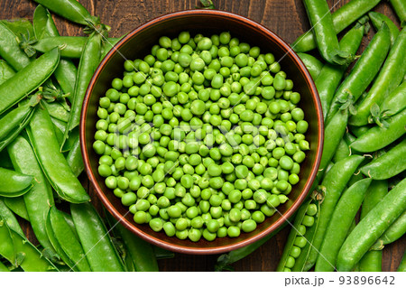 green sweet peas on a dark wooden background, still life, concept of fresh and healthy food green sweet peas on a dark wooden background, still life, concept of fresh and healthy food 93896642