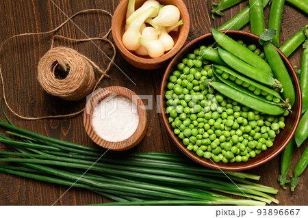 green sweet peas on a dark wooden background, onion, salt, still life, concept of fresh and healthy food green sweet peas on a dark wooden background, onion, salt, still life, concept of fresh and healthy food 93896667